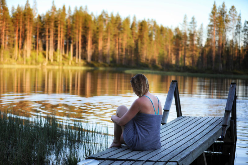 Nainen laiturilla järven rannalla Posiolla. Kuva: Harri Tarvainen & Visit Finland