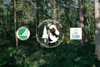Ympäristömerkkisitoumuksen logot, taustalla kuvituksena metsää